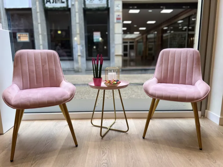 Zona de elegantes butacas rosas con mesa a juego en Peluquera atiende cliente en PELUQUERIA-NIMUS-POLA-SIERO